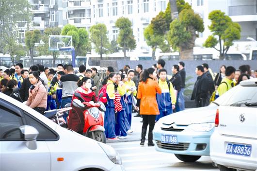 正規校車不見蹤影 “校車難題”困煞3600名學生 圖為:放學后,很多家長開車接孩子回家