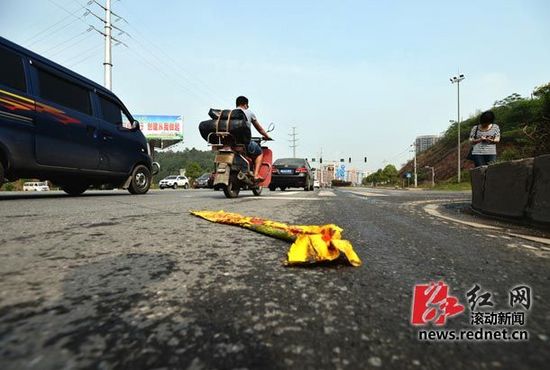 長(zhǎng)沙生態(tài)動(dòng)物園附近五車相撞 有四輛黃色校車 地上殘留著校車玻璃碎片,有塊塑料布上寫著“請(qǐng)停車等候”的字。圖/滾動(dòng)新聞?dòng)浾? border=