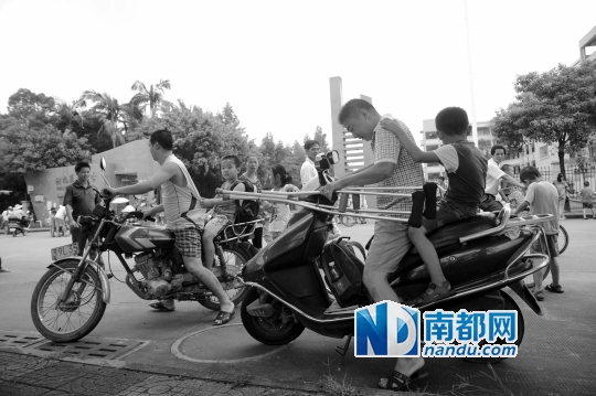 <p>因校車座位不夠，洪梅第二小學(xué)今年的新莞人新生不能坐校車，許多家長只能騎車接送孩子。南都記者劉在富攝<br /><br /></p>