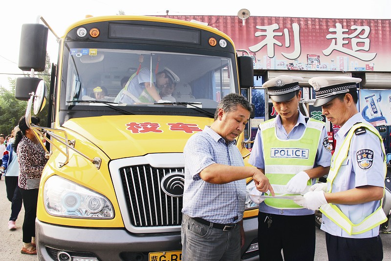 民警在進行校車安全檢查的同時,向駕駛員宣傳相關安全規定