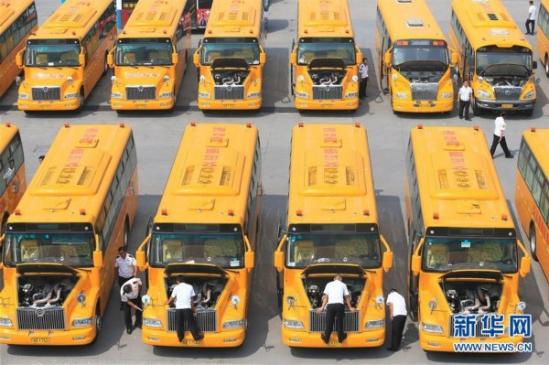 山東青島交運集團即墨分公司的校車駕駛員在巡檢車輛安全狀況（2015年8月23日攝）。 12月17日，從山東青島市教育局獲悉，截至目前，青島市共有1600輛專用校車，服務400余所學校，惠及12余萬名學生，成為全國校車運營規模最大的城市，并逐步確立了政府主導、部門監管、企業運作、財政補貼、統一標準的校車運營模式。新華社發（梁孝鵬 攝）